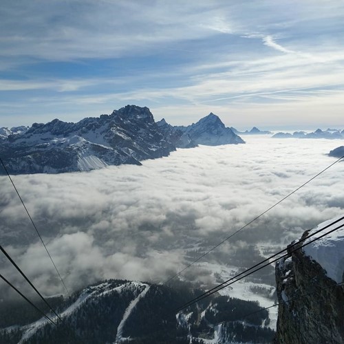 mountains from above clouds below chairlift