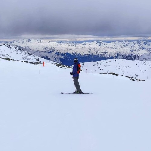 skier on the slopes from behind mountain view