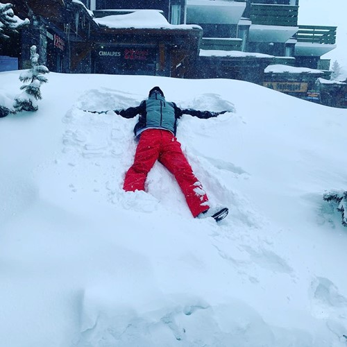 man doing snow angel in fresh powder