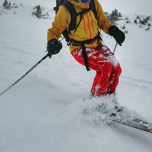 woman skiing through powder on slopes