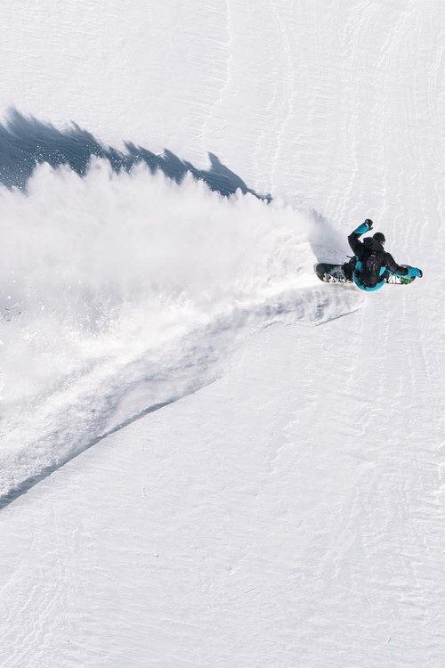 Birds eye view of a snowboarder shredding powder in Courmayeur