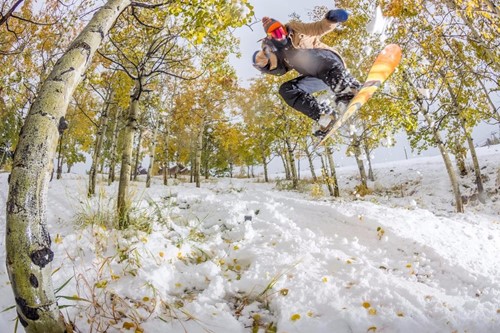 Aspen Snowmass boarder jumping through trees